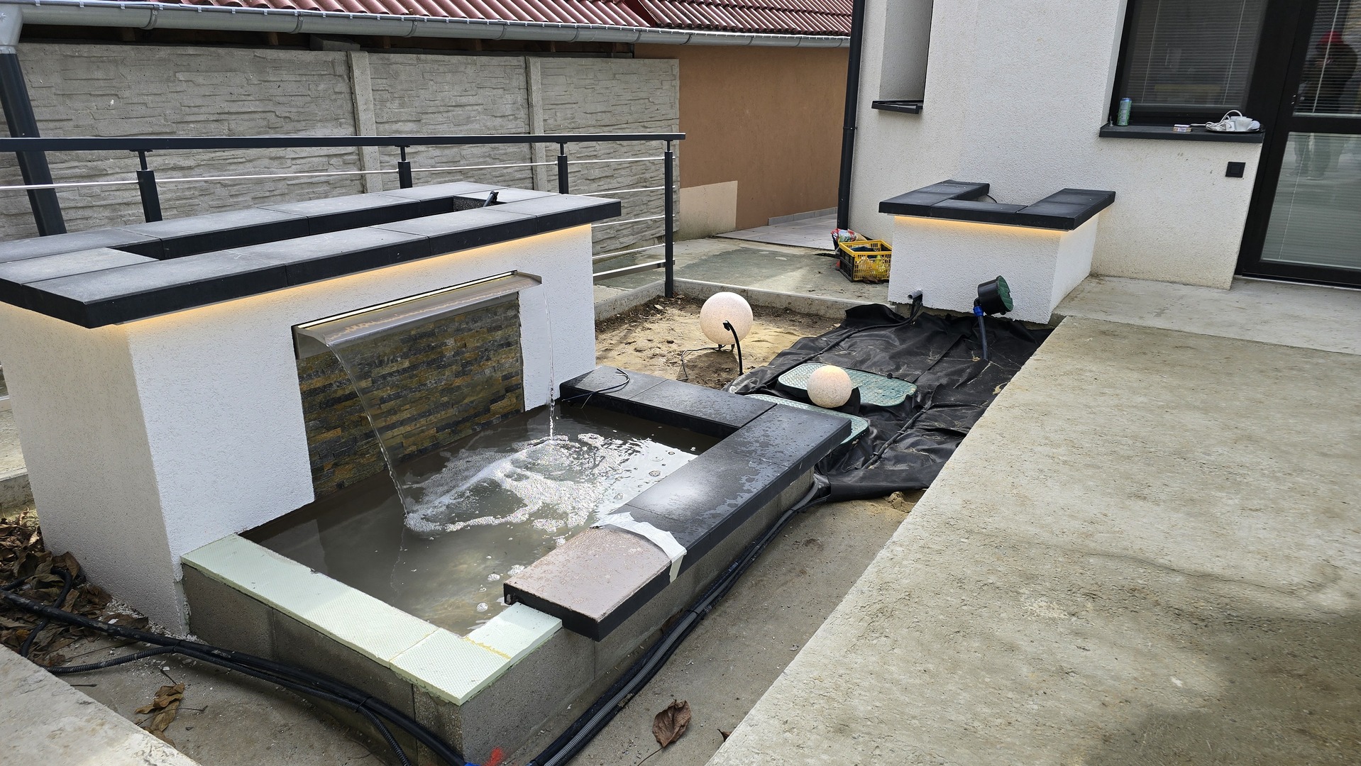 Moderná vodná stena s podsvietením a prepadom do jazierka v Plaveckom Štvrtoku